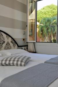a bedroom with a bed and a window with a palm tree at Hotel Helios in Santa Margherita Ligure