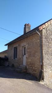 un pequeño edificio de piedra con una puerta blanca en Gite des Celliers en Alise-Sainte-Reine