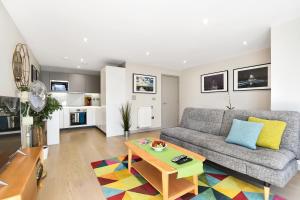 a living room with a couch and a table at Esquire Apartments Ealing in London