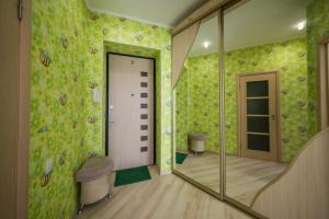 a bathroom with green wallpaper and a mirror at Апартаменты на площади Ленина от ApartmentCity in Mogilev
