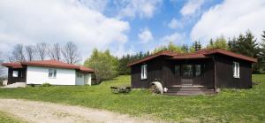 uma pequena casa num campo ao lado de uma estrada de terra em Szałas Muflon - Mufflonhütte em Jelenia Góra