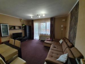 sala de estar con sofá y TV en Baby Apartman en Hajdúszoboszló