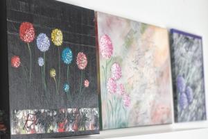 a row of paintings on a wall with flowers at La Vela in Rovinj