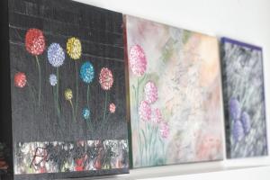 una fila de pinturas en una pared con flores en La Vela, en Rovinj