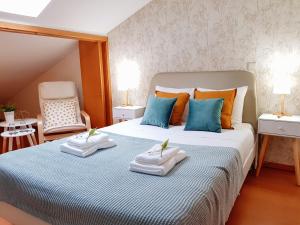 Braga Bells Guesthouse في براغا: غرفة نوم عليها سرير وفوط