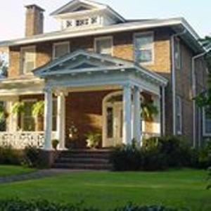 a large brick house with a porch and a porch at Port City Guest House in Wilmington