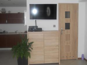 a flat screen tv on top of a wooden cabinet at U Derca in Gnieżdżewo