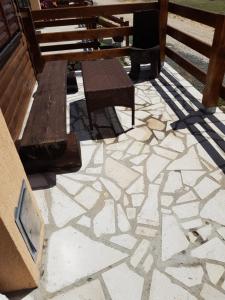 a patio with a bench and a stone floor at Zabljak Panoramic View Lodge in Žabljak