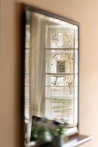 espejo reflejo de una ventana en una habitación en Penzion U Hrádku en Kutná Hora