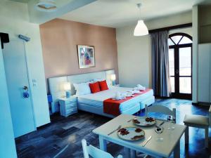 a hotel room with a bed and a table with plates on it at Creta Sun Studios in Kato Daratso