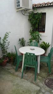 JubriqueにあるJúbriqueの白いテーブルと緑の椅子2脚