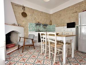 een keuken met een tafel en stoelen en een open haard bij Villa Janas in Baunei