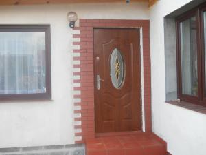 een houten deur aan de zijkant van een huis bij U Derca in Gnieżdżewo
