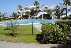 a tennis court in front of a large building at Novo Sancti Petri Atardecer Planta baja in Chiclana de la Frontera