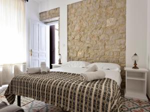 a bedroom with a bed with a stone wall at Villa Janas in Baunei
