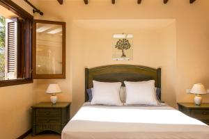 1 dormitorio con 1 cama con 2 mesitas de noche y 2 lámparas en Sa Rondalla - Formentera en Playa de Migjorn