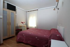 sypialnia z łóżkiem z fioletowym kocem w obiekcie El Centro w mieście Vargas