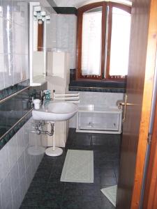 bagno bianco con lavandino e specchio di B&b Margherita a Calasetta