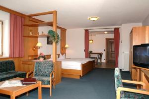 a hotel room with a bed and a television at Hotel Märchenwald in Haidmühle