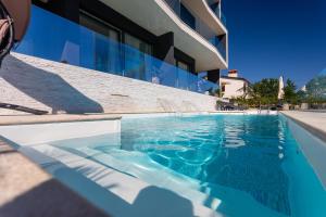 a swimming pool in front of a building at Villa Valis in Baška