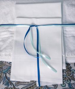 a pair of white napkins with a blue ribbon at Hotel Acquamarina in Portoferraio