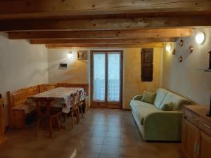 un soggiorno con un divano e un tavolo di Maisonnette de montagne a Ollomont