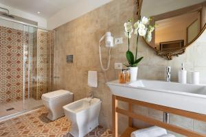 a bathroom with a sink and a toilet and a mirror at Corte Realdi Luxury Rooms Torino in Turin