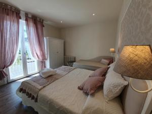 1 dormitorio con 1 cama con lámpara y ventana en Romantic Home en Sirmione