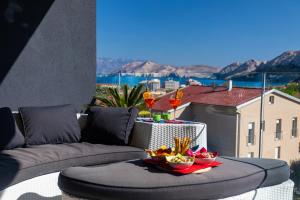 a balcony with a couch and a bowl of food at Villa Valis in Baška