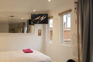 a bedroom with a bed and a television on the wall at Urban Log Cabin near zone 2 tube in London