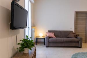 a living room with a couch and a flat screen tv at Domus Verona - Ampia residenza Filippini a pochi passi dall'Arena in Verona