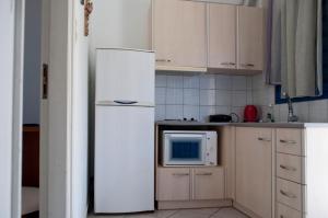 a kitchen with a white refrigerator and a microwave at Hara's Studio in Perdika