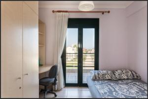 a bedroom with a bed and a desk and a window at Oxana house in Nea Moudania