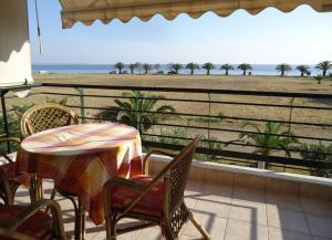 a patio with a table and chairs and a view of the beach at Oxana house in Nea Moudania