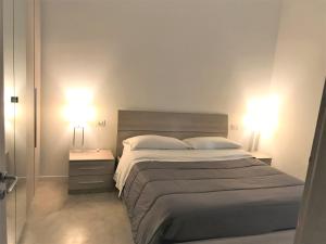 1 dormitorio con 1 cama grande y 2 lámparas en Apartments Porta Venezia - Milan downtown, en Milán
