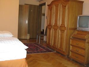 Hotel Eilenriede في هانوفر: غرفة نوم مع سرير وتلفزيون في خزانة