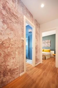 a room with a stone wall with a sliding glass door at Suite Manin in Treviso