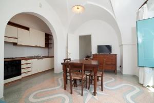 eine Küche mit einem Holztisch und Stühlen im Zimmer in der Unterkunft Villa Raffaella in Santa Cesarea Terme