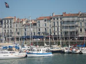 a group of boats docked in a harbor with buildings at Hotel La Marine, Vieux Port in La Rochelle
