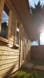 una casa de madera con ventanas laterales. en Urban Log Cabin near zone 2 tube, en Londres