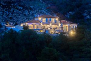 a large house sitting on top of a hill at night at Villa Terra Rogoznica in Rogoznica