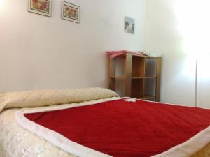 een slaapkamer met een rode deken op een bed bij Centro Piave Apartment in Trento