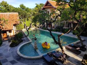 einen Blick über einen Pool mit Menschen darin in der Unterkunft Puri Mesari Hotel in Sanur