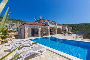 a villa with a swimming pool in front of a house at Villa Terra Rogoznica in Rogoznica