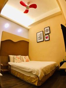 a bedroom with a bed with a ceiling fan at I WoW in Xiaoliuqiu