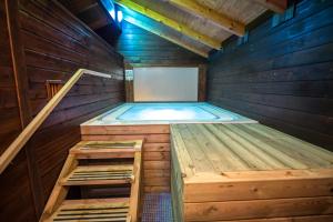 uma banheira de hidromassagem numa sauna de madeira com escadas em El Caseron de Conil & Spa em Conil de la Frontera