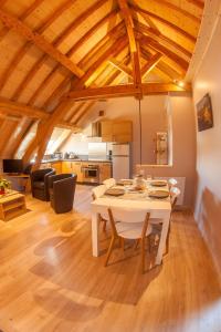 eine Küche und ein Wohnzimmer mit einem weißen Tisch und Stühlen in der Unterkunft Gite de la Petite Ecole in Lans-en-Vercors