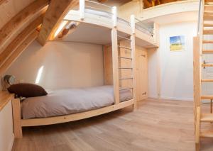 Etagenbett in einem Zimmer mit einer Treppe in der Unterkunft Gite de la Petite Ecole in Lans-en-Vercors