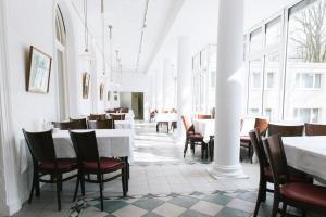 a dining room with white tables and chairs at Europäische Akademie Berlin in Berlin