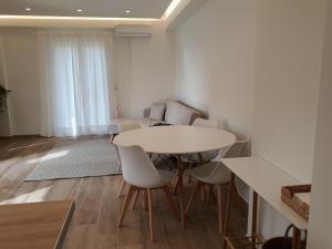 une salle à manger avec une table et des chaises blanches dans l'établissement Apartment Laoura, à Corfou